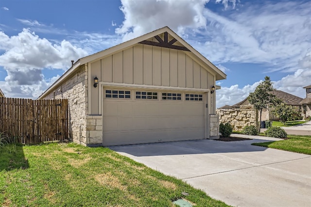 garage featuring concrete driveway and fence