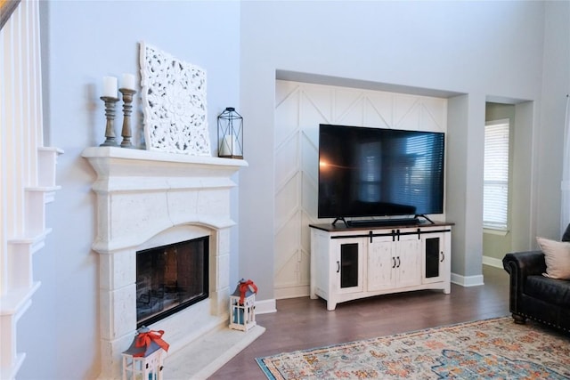 living area with baseboards, dark wood-style flooring, and a premium fireplace