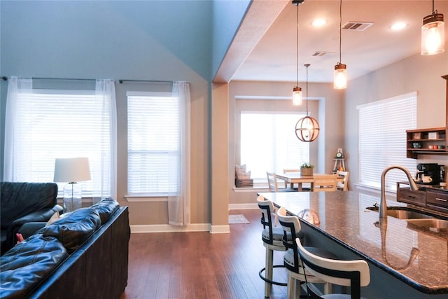 kitchen with dark wood-type flooring, plenty of natural light, visible vents, and a sink