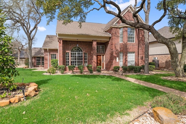 view of front of home featuring brick siding and a front yard