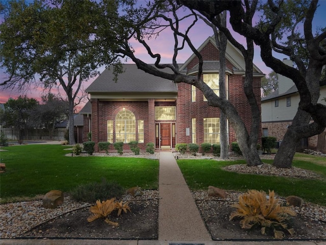 view of front of home with a front yard and brick siding