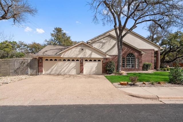 view of front facade with a front yard, fence, driveway, a garage, and brick siding