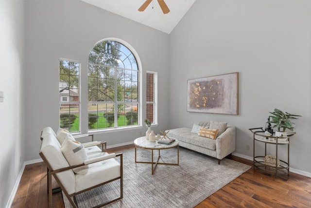 living room with high vaulted ceiling, wood finished floors, baseboards, and ceiling fan