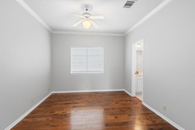 spare room featuring hardwood / wood-style floors, crown molding, a ceiling fan, and visible vents