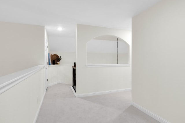 corridor featuring baseboards and carpet floors