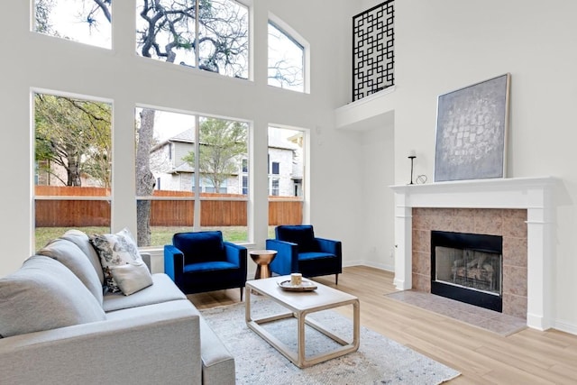 6717 Blissfield Dr, Austin, TX 78739 - living area with wood finished floors, a tiled fireplace, and a high ceiling