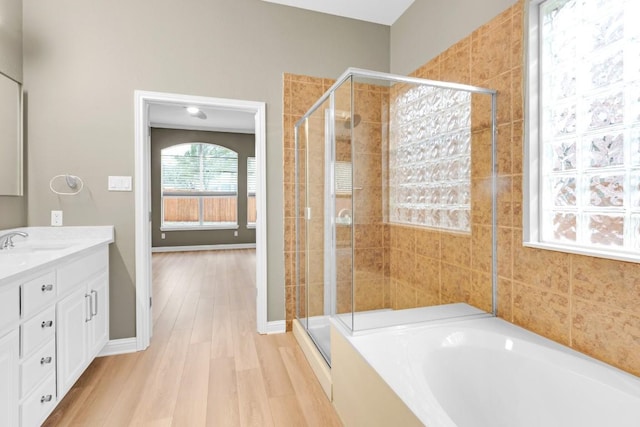 bathroom with a garden tub, vanity, wood finished floors, and a shower stall