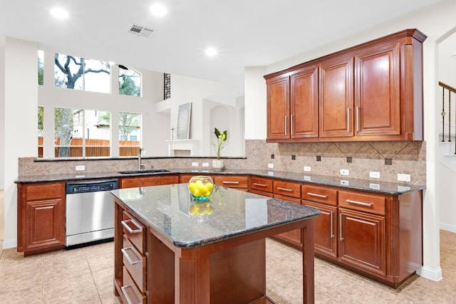 kitchen featuring visible vents, brown cabinets, backsplash, dark stone counters, and dishwasher