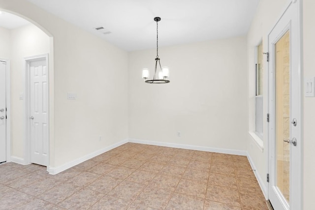 unfurnished room with visible vents, arched walkways, a notable chandelier, and baseboards