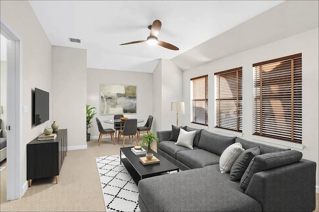 living room featuring baseboards, visible vents, ceiling fan, vaulted ceiling, and light carpet