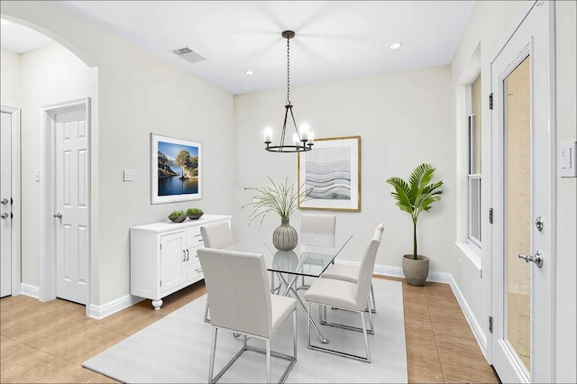 dining area with visible vents, baseboards, light tile patterned flooring, arched walkways, and a notable chandelier