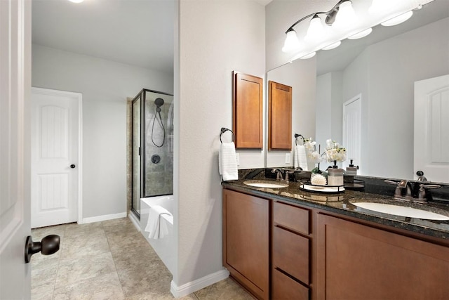 full bath with double vanity, shower / bath combination with glass door, baseboards, and a sink