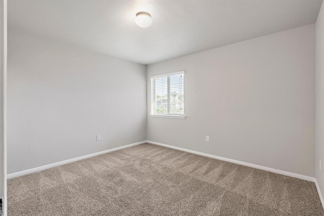 empty room featuring baseboards and carpet flooring