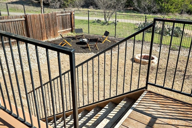 view of gate with a yard, a fire pit, and a fenced backyard