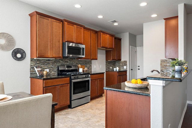 kitchen with visible vents, backsplash, appliances with stainless steel finishes, a peninsula, and light tile patterned floors