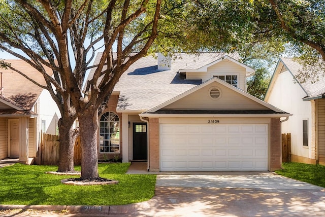 view of front facade featuring brick siding, driveway, an attached garage, and fence