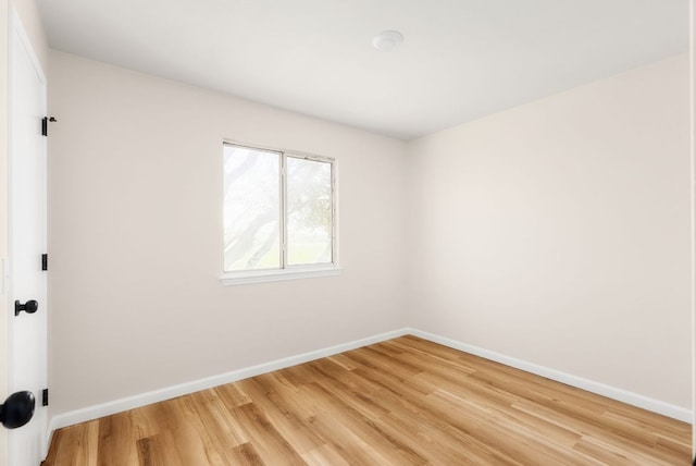 empty room with baseboards and light wood finished floors