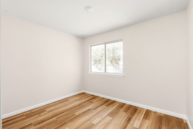 spare room featuring light wood-style flooring and baseboards