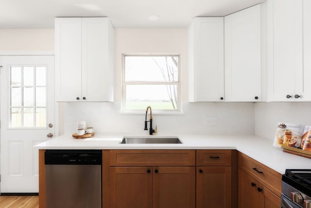 kitchen featuring a sink, appliances with stainless steel finishes, a wealth of natural light, and light countertops