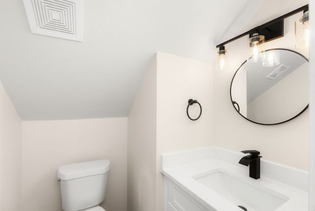 bathroom featuring visible vents, toilet, vanity, and lofted ceiling