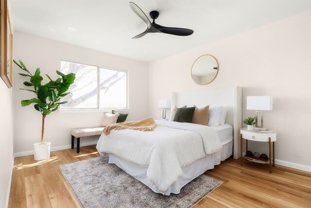 bedroom featuring ceiling fan, baseboards, and light wood-style floors