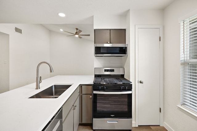 kitchen featuring visible vents, ceiling fan, light countertops, stainless steel appliances, and a sink