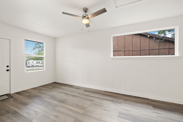 unfurnished room with a wealth of natural light, baseboards, and wood finished floors