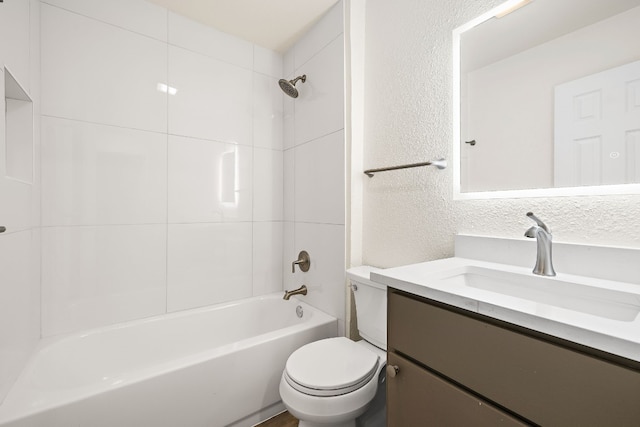 full bathroom with shower / tub combination, toilet, vanity, and a textured wall