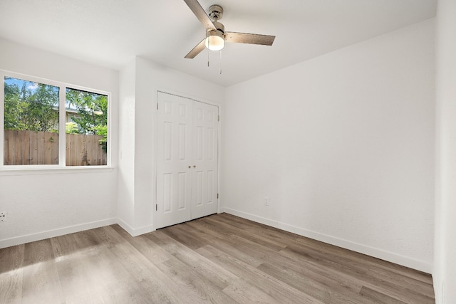 unfurnished bedroom with light wood-style floors, baseboards, and a closet