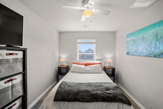 bedroom featuring visible vents, a ceiling fan, baseboards, and wood finished floors