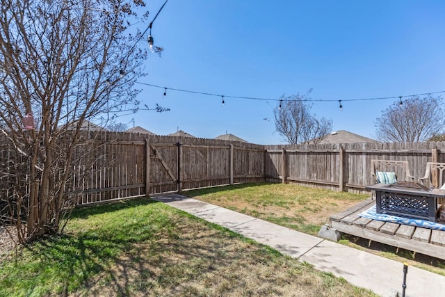 view of yard with a fenced backyard and an outdoor fire pit