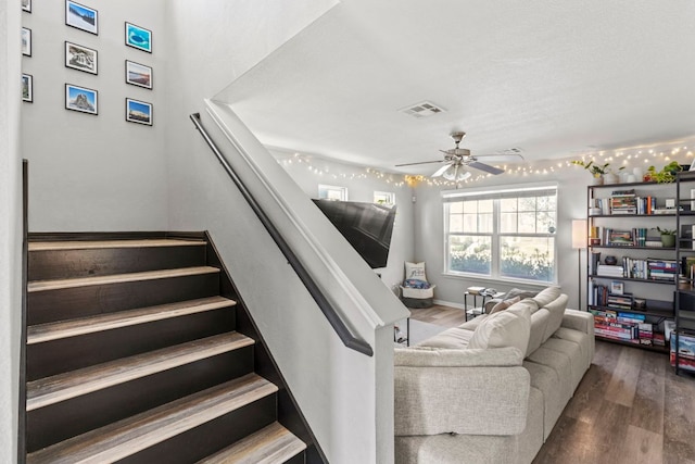 stairs with ceiling fan, visible vents, and wood finished floors