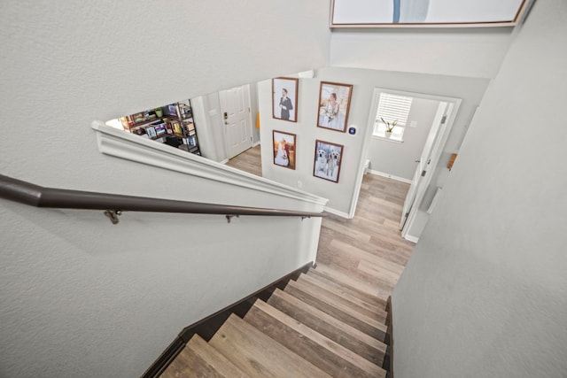 stairway featuring wood finished floors and baseboards