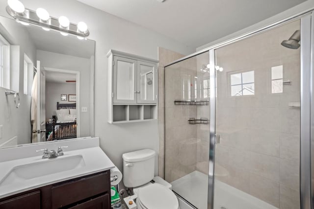 bathroom featuring vanity, toilet, and a shower stall