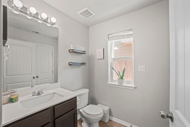 bathroom with visible vents, baseboards, toilet, and vanity