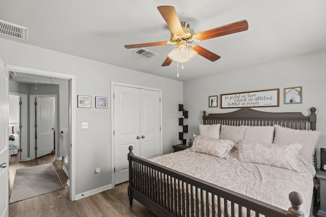 bedroom featuring a closet, visible vents, attic access, and wood finished floors