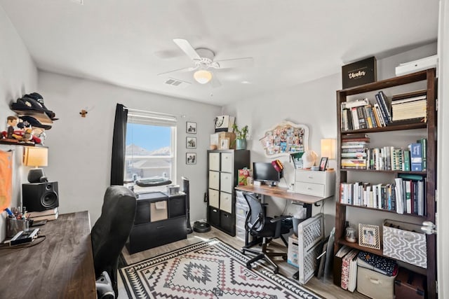 home office with visible vents, wood finished floors, and a ceiling fan