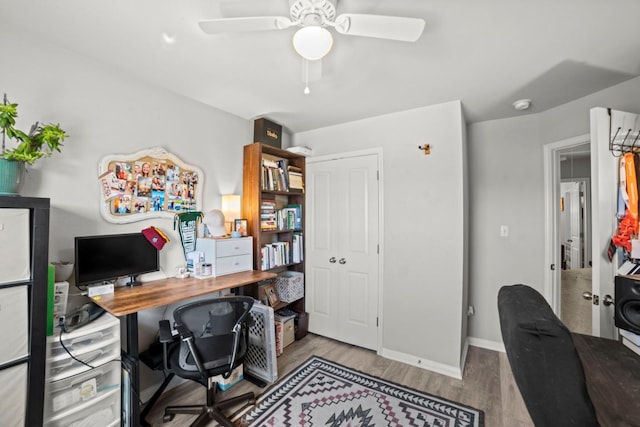 office featuring a ceiling fan, wood finished floors, and baseboards