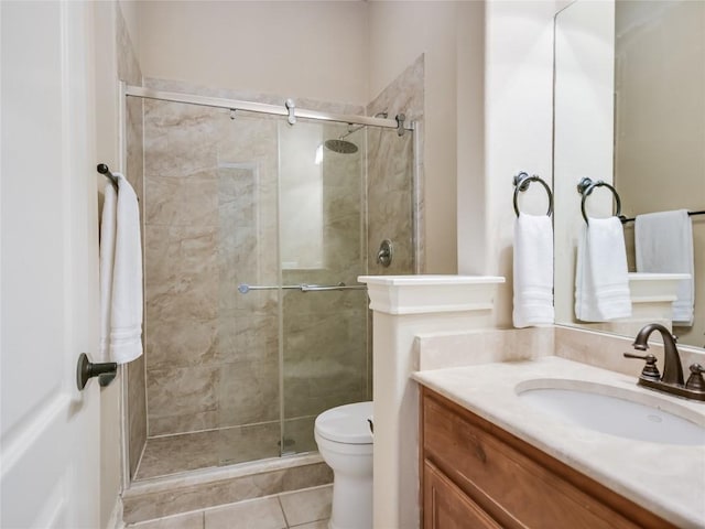 full bathroom with vanity, a shower stall, toilet, and tile patterned flooring