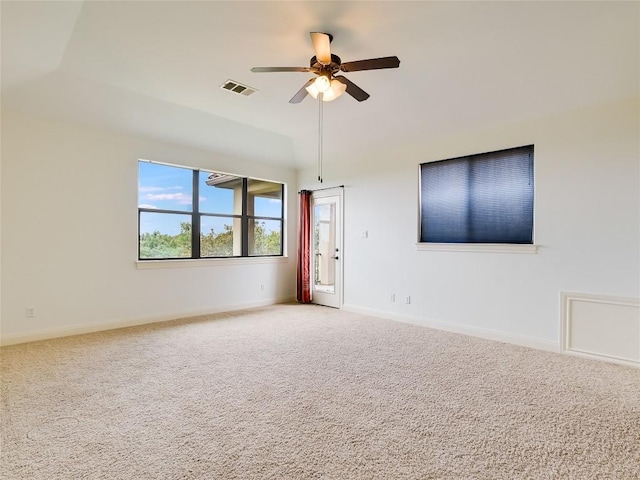 carpeted spare room featuring visible vents, baseboards, and ceiling fan