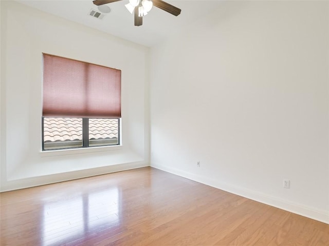 spare room with visible vents, baseboards, ceiling fan, and wood finished floors