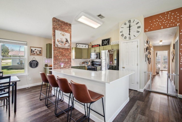 kitchen with a wealth of natural light, stainless steel appliances, tasteful backsplash, and green cabinets