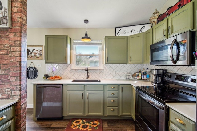 kitchen featuring stainless steel appliances, green cabinets, light countertops, and a sink