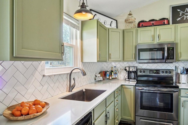 kitchen with a sink, appliances with stainless steel finishes, light countertops, and green cabinetry