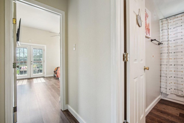 hallway with french doors, baseboards, and dark wood-style floors