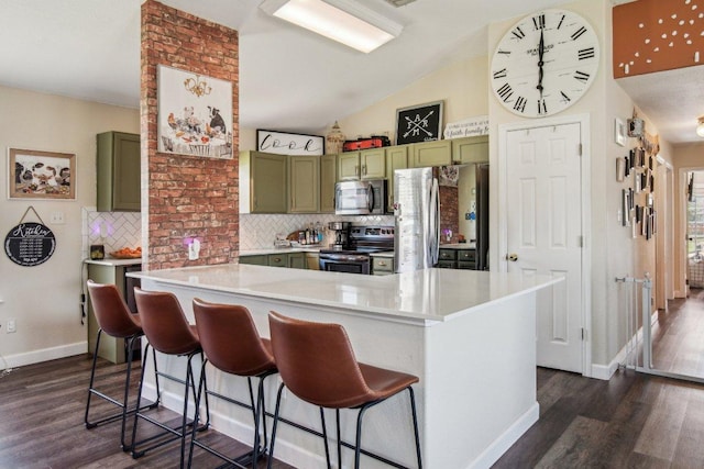 kitchen with tasteful backsplash, dark wood-style floors, stainless steel appliances, light countertops, and green cabinetry