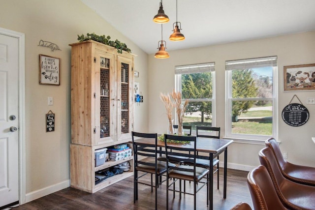 dining room with plenty of natural light, dark wood finished floors, and vaulted ceiling