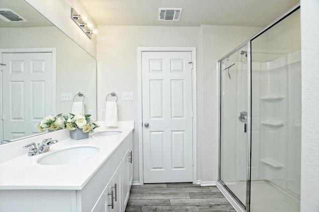 full bath with a sink, visible vents, and wood finished floors