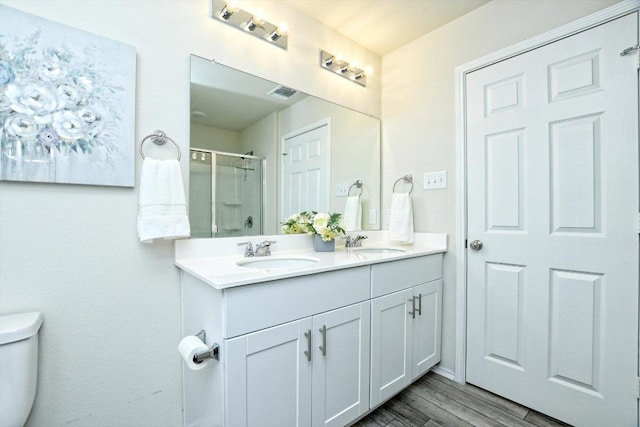 bathroom featuring a stall shower, toilet, visible vents, and a sink