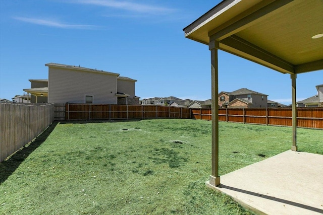 view of yard featuring a fenced backyard, a residential view, and a patio